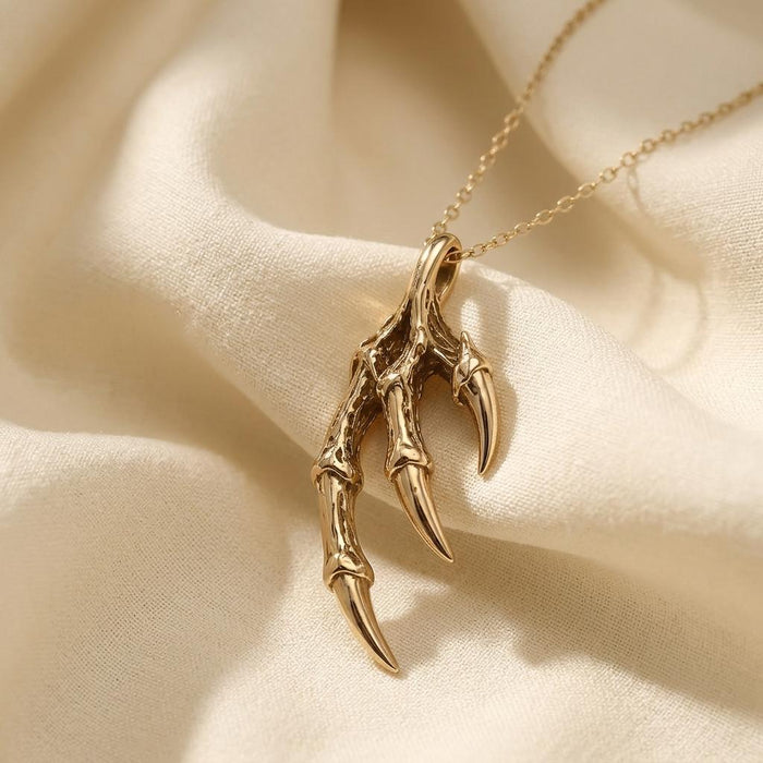 Gold Plated Silver Dragon Claw Pendant Necklace close-up on ivory satin