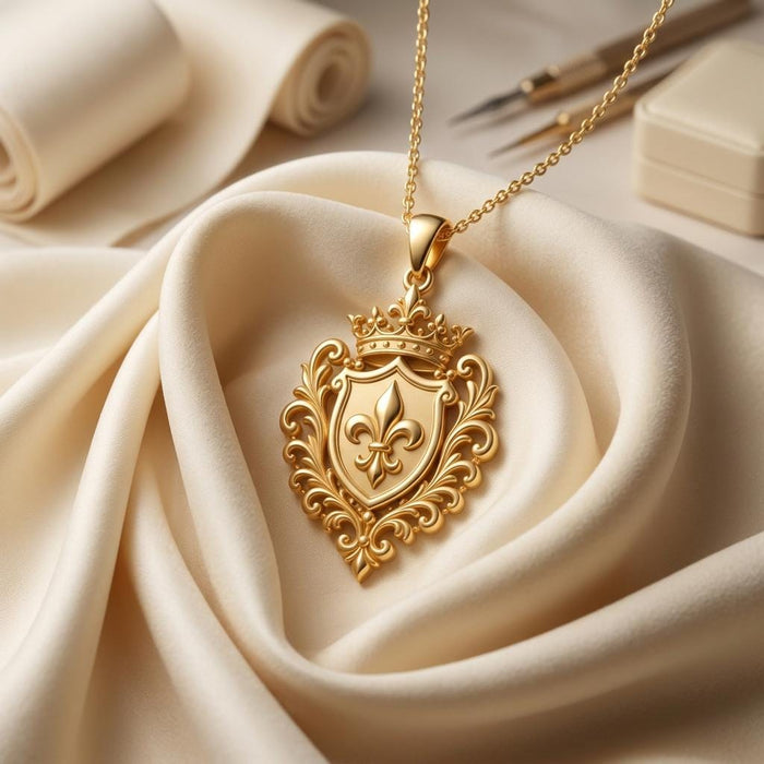 Dynasty Emblem Necklace in Gold Plated Silver displayed on cream satin beside books and a pen