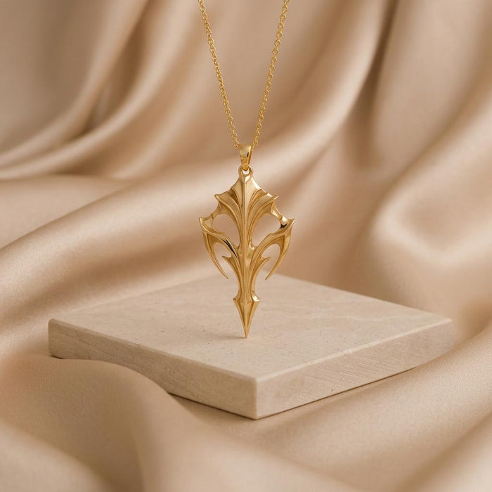 Gold Plated Silver Eclipse Armor Pendant displayed upright on a light stone block