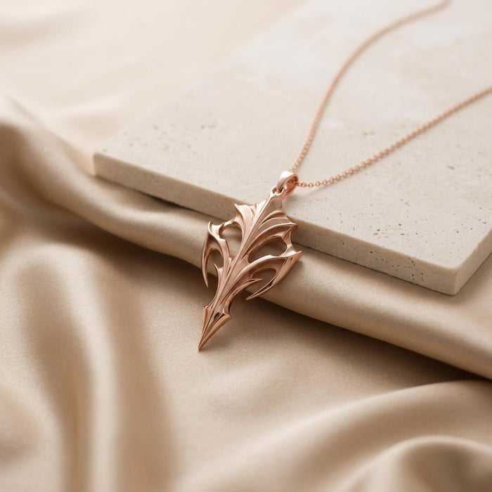 Rose Gold Plated Eclipse Armor Pendant arranged beside a light stone block on beige satin