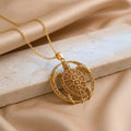 Gold Plated Silver Eclipse Turtle Relic pendant on a pale stone block with champagne satin