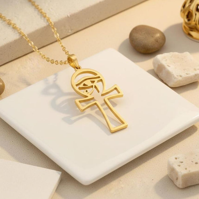 Gold Plated Silver Egyptian Ankh Cross pendant displayed on a white tile with neutral stones