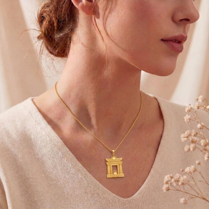 Model wearing a Gold Plated Silver Egyptian Solar Gate pendant necklace with a cream sweater