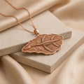 Rose Gold Plated Elasmosaurus Fossil Pendant with raised skeleton relief on textured stone blocks