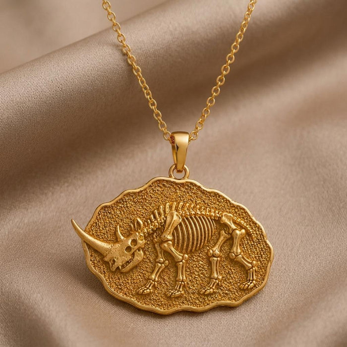 Gold Plated Silver Elasmotherium Fossil Pendant with a horned skeletal relief on champagne satin