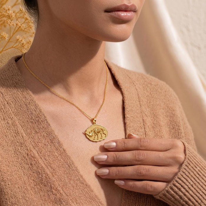 Model wearing a Gold Plated Silver Elasmotherium Fossil Pendant over a neutral knit top