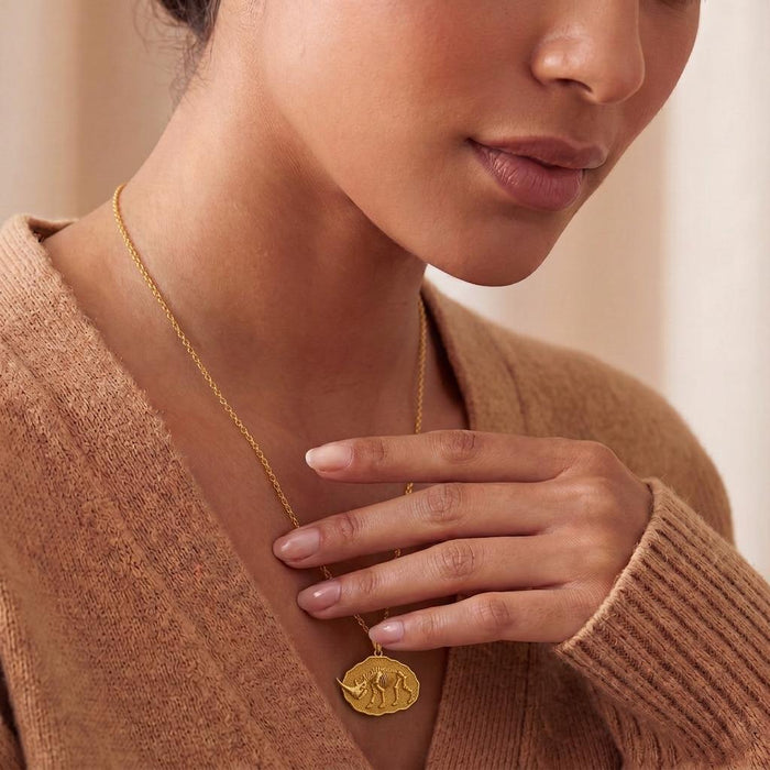 Close worn view of a Gold Plated Silver Elasmotherium Fossil Pendant on a model