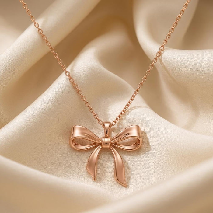 Rose Gold Plated Elegant Bow Pendant Necklace with pointed ribbon tails on champagne satin