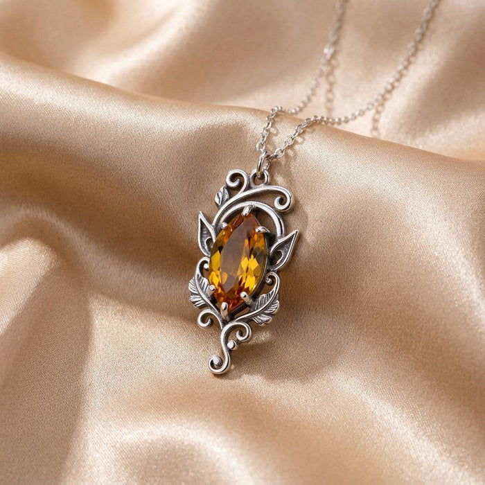Elven Birthstone Necklace on champagne satin showing marquise stone, leaf details, and lower feather-like accents