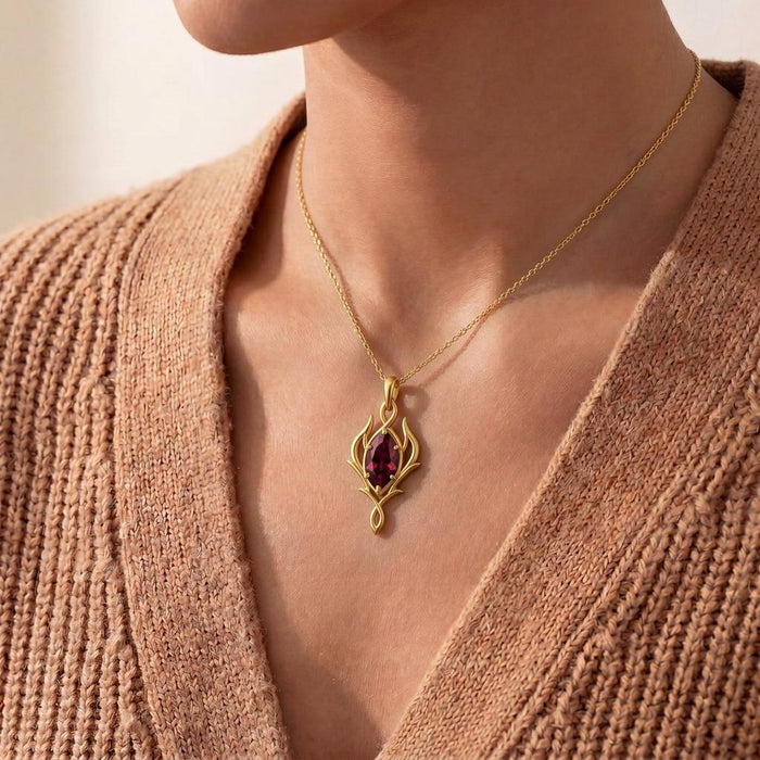 Gold Plated Silver Elven Marquise Birthstone Necklace with a red marquise-shaped stone worn with a knit cardigan