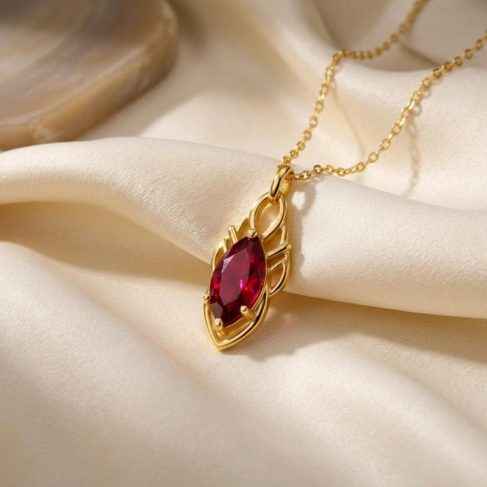 Close view of the Elven Ruby Necklace with ruby-red marquise center on ivory satin