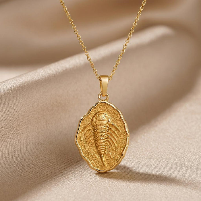 Gold Plated Silver Eurypterid Fossil Pendant Necklace with a raised segmented relief on champagne satin
