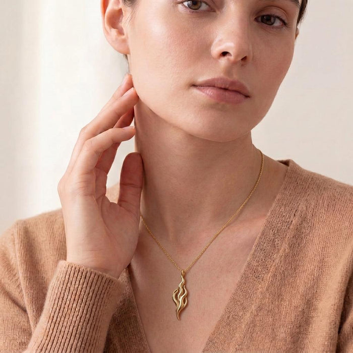 Model wearing a Gold Plated Silver Flame of Venus pendant necklace with a vertical openwork flame design