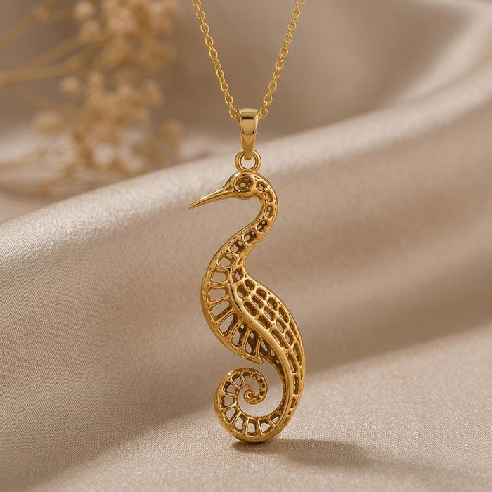 Gold Plated Silver Fossil Crane Pendant Necklace with an openwork crane and spiral tail on champagne satin