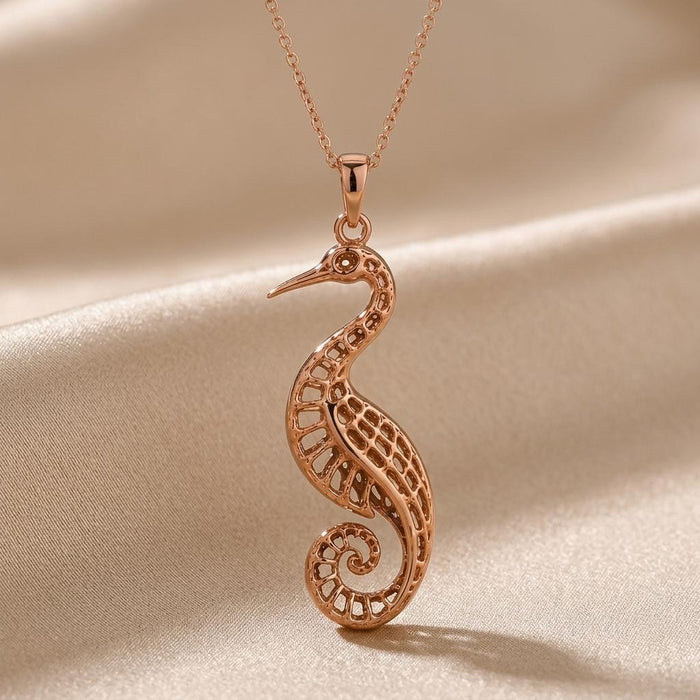 Rose Gold Plated Fossil Crane Pendant close view showing the pointed beak, patterned wing, and spiral tail