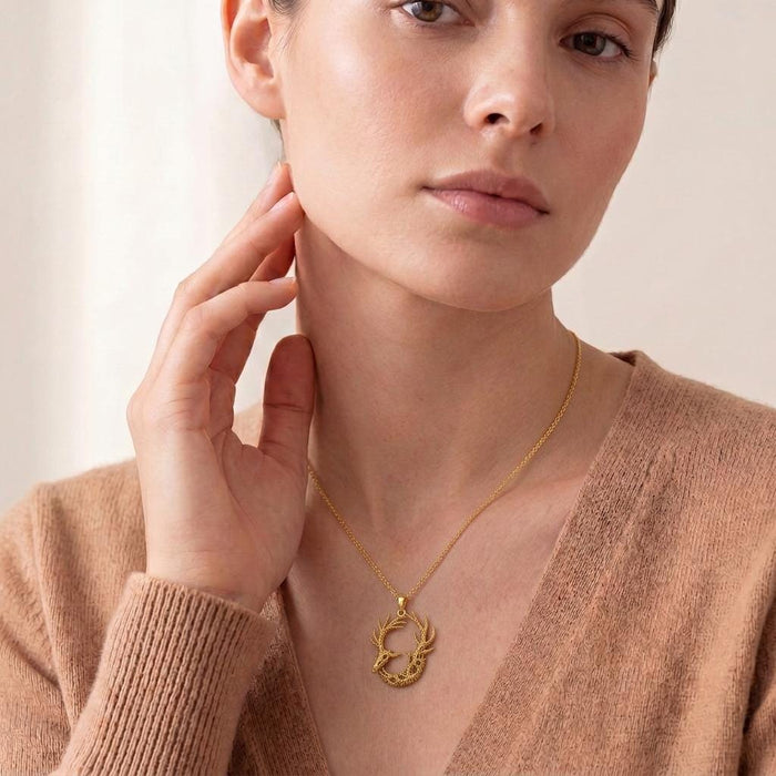 Model wearing a Gold Plated Silver Fossil Deer Relic pendant necklace with a beige knit top