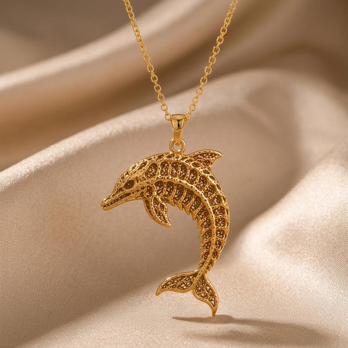 Gold Plated Silver openwork Fossil Dolphin Artifact pendant necklace displayed on champagne satin