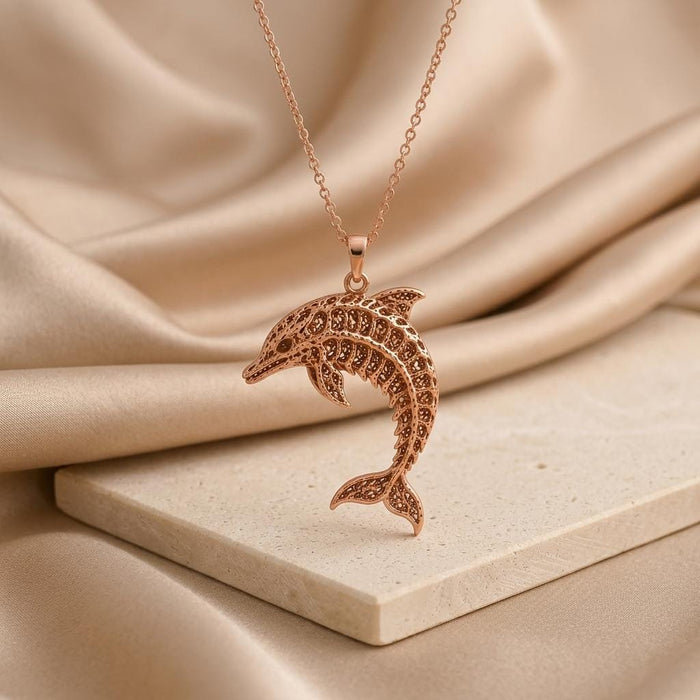 Rose Gold Plated Fossil Dolphin Artifact Necklace with openwork dolphin pendant on a stone display block