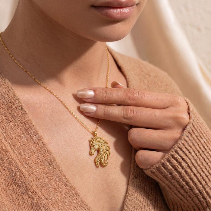 Gold Plated Silver Fossil Horse Crest Necklace worn at the neckline with a knit cardigan