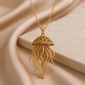 Gold Plated Silver Fossil Jellyfish Halo necklace on champagne satin beside a rectangular stone block