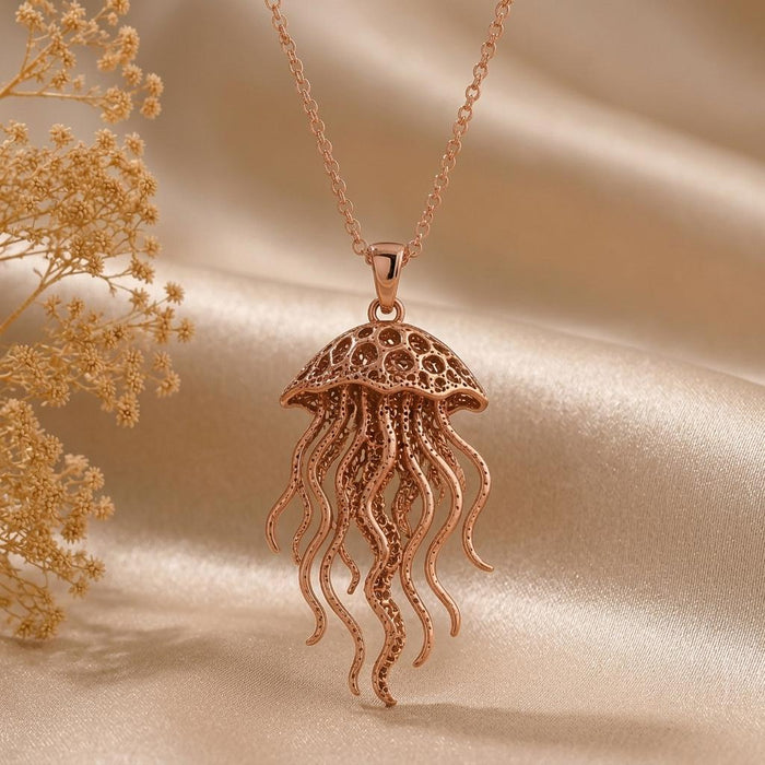 Rose Gold Plated Fossil Jellyfish Halo pendant on champagne satin with dried flowers at the left edge