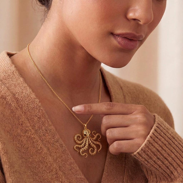 Model holding the Gold Plated Silver Fossil Octopus Spine Pendant Necklace against a knit top