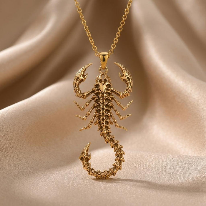 Close product view of Gold Plated Silver skeletal scorpion pendant on cream satin