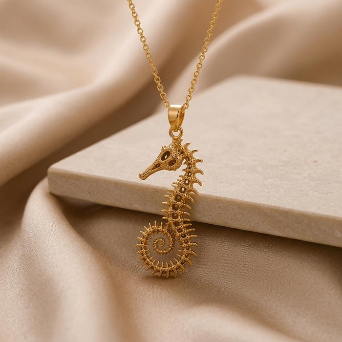 Close-up of a Gold Plated Silver fossil seahorse spine pendant with openwork body segments and curled tail