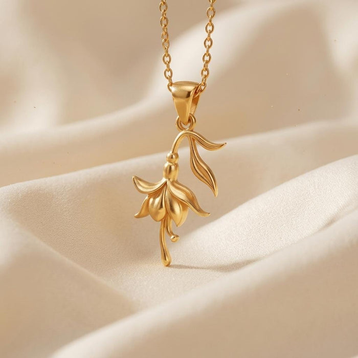 Gold Plated Silver Fuchsia Flower Necklace with a downward-facing cascading petal pendant on ivory fabric