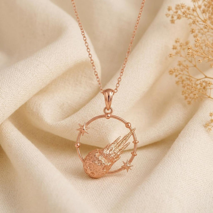 Rose Gold Plated Galactic Meteor Halo pendant with a textured meteor on cream fabric