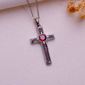 Garnet Birthstone Cross Necklace in Silver on pale fabric with dried flowers