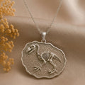 Silver Gastornis Fossil Pendant Necklace with raised skeletal bird relief on a textured irregular medallion