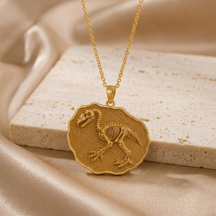 Gold Plated Silver Gastornis fossil pendant with raised bird skeleton relief on a stone block