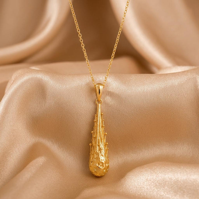 Gold Meteor Core Necklace in Gold Plated Silver with a textured elongated drop pendant on champagne satin
