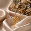 Golden Nebula Pendant Necklace in Gold Plated Silver with an elongated openwork spiral, bead-like details, and two pointed star accents on champagne satin