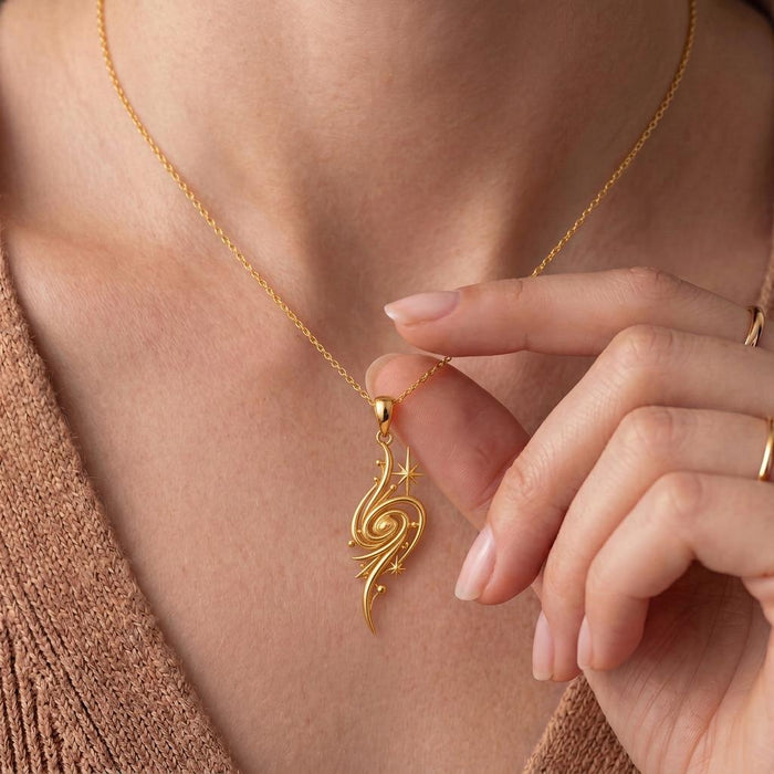 Close view of the Golden Nebula Pendant Necklace in Gold Plated Silver worn at the collarbone, showing the spiral and star accents