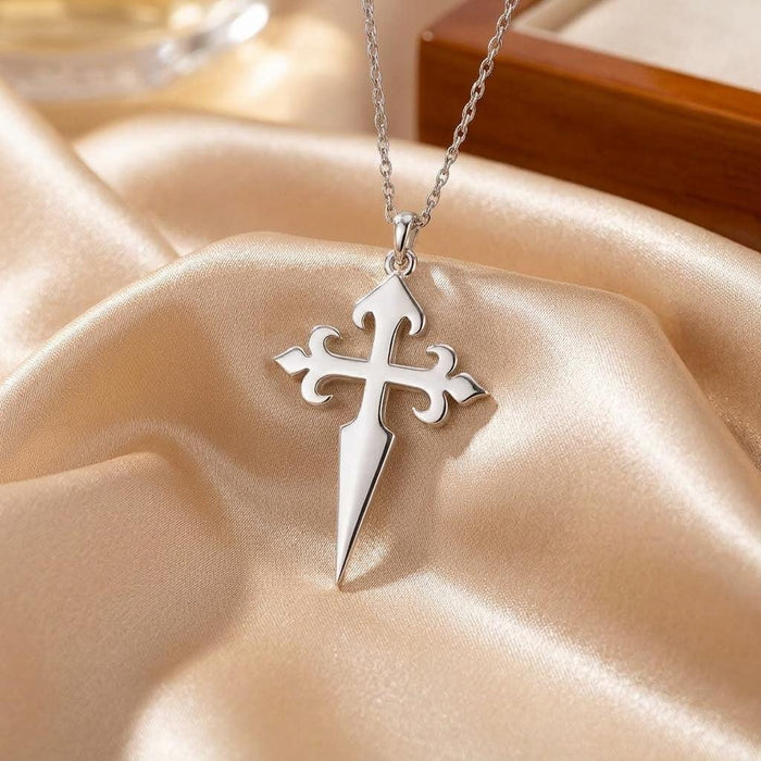 Close-up of the Gothic Cross Dagger Pendant Necklace on champagne satin