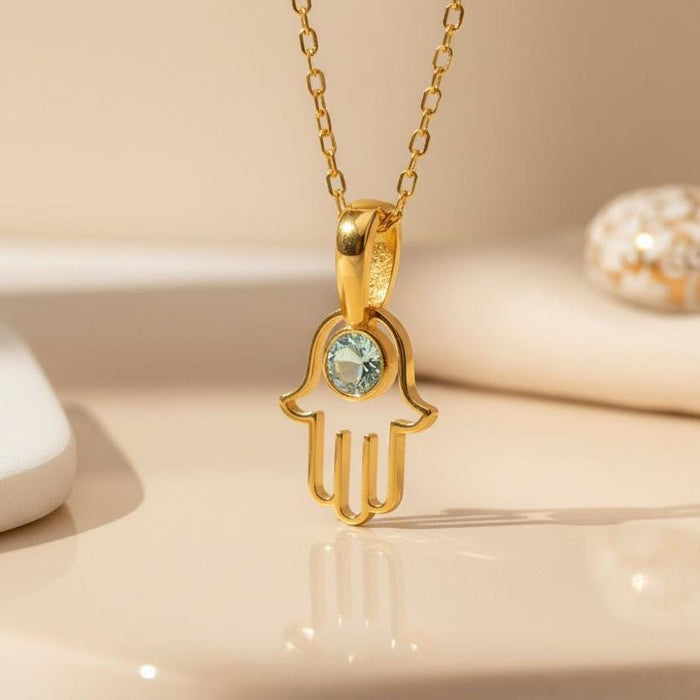 Gold Plated Silver Hamsa pendant close-up with a pale blue round center stone