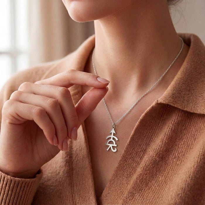 Achilles Symbol Necklace worn with a brown knit top, showing the vertical openwork pendant at the neckline