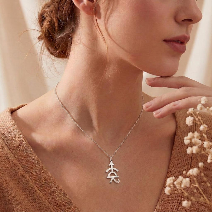 Achilles Symbol Necklace worn at the collarbone with white flowers in the foreground