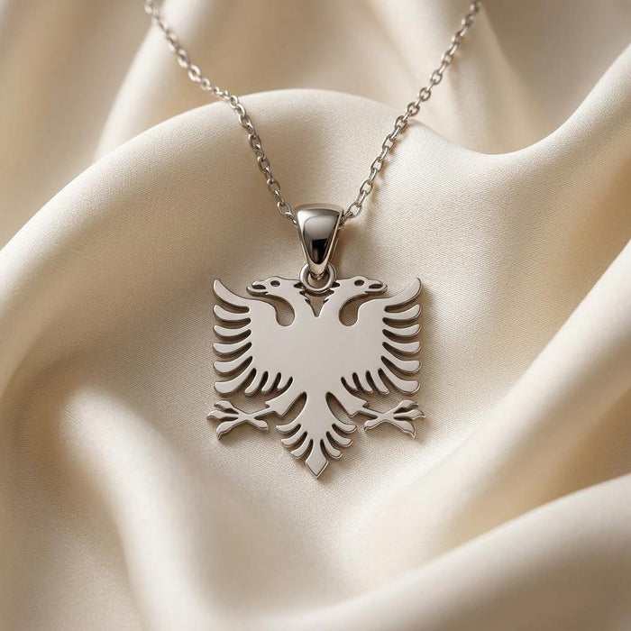 Silver double headed Albanian eagle pendant necklace displayed on ivory satin