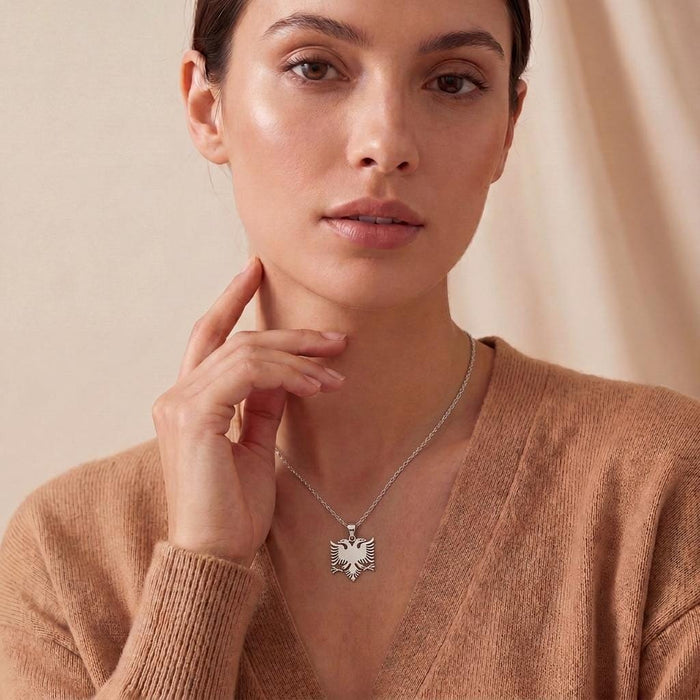 Front-facing model wearing a silver Albanian Eagle Necklace with a tan cardigan