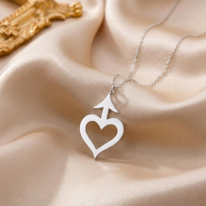 silver Amor Symbol Necklace with open heart and arrow pendant on champagne satin