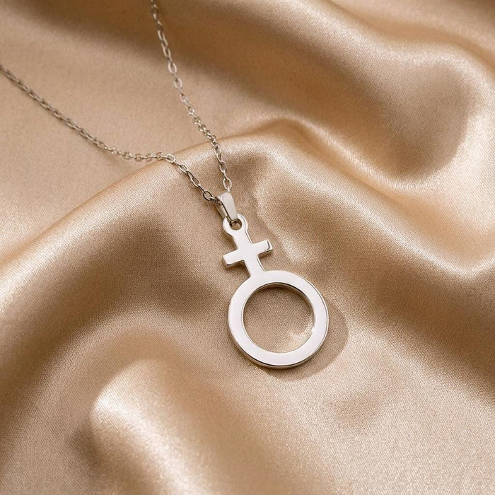 Close-up of a Silver Antimony cross-and-open-circle pendant on champagne satin