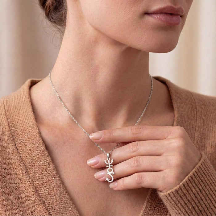 Model holding the Apophis Symbol Necklace pendant at the neckline