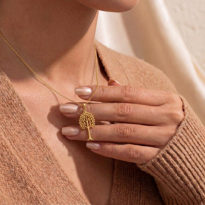 Close view of the Gold Plated Silver Aspen Glow tree pendant held at the neckline