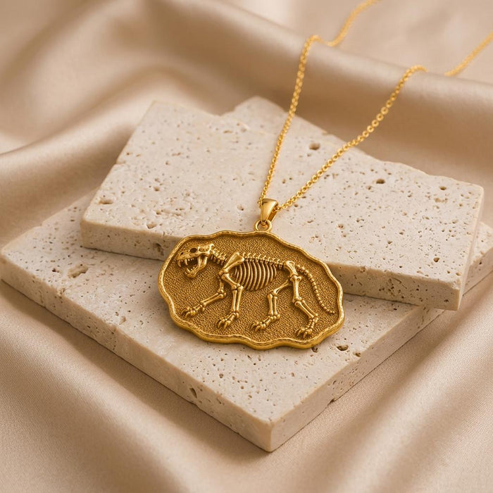 Gold Plated Silver Cave Lion Fossil Pendant displayed on stacked pale stone tiles and champagne satin
