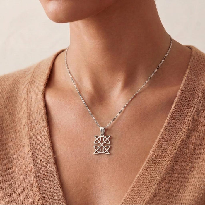 Celtic Knot Necklace with two stacked openwork knot panels worn at the collarbone with a beige knit top
