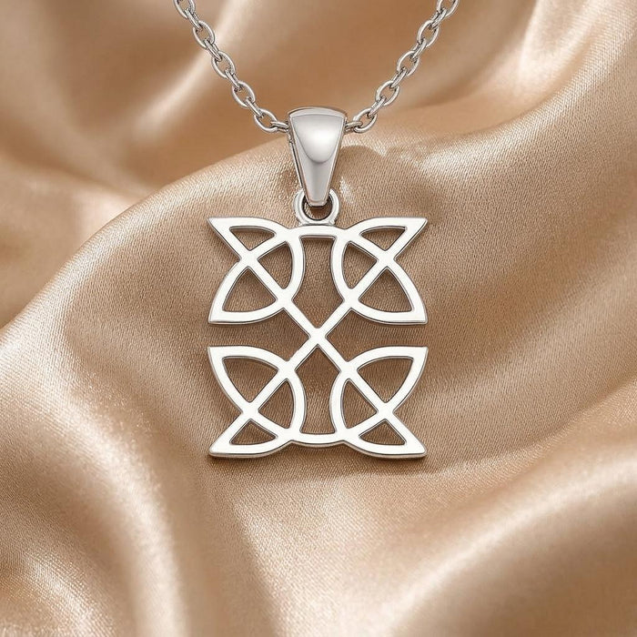 Macro view of two vertically stacked openwork Celtic knot panels on champagne satin
