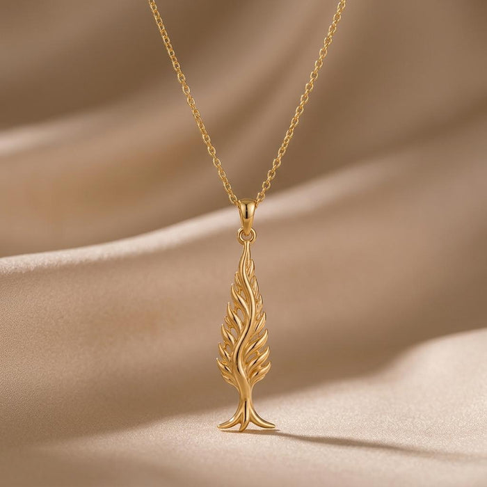 Close-up of the Gold Plated Silver Cypress Flame Pendant against beige draped fabric